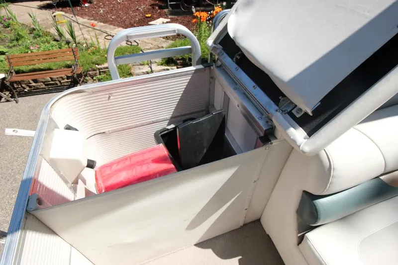 Slide: The Image of 2002 Princecraft Versailles 22 SS boat storage compartment with open seat and visible items. - 21