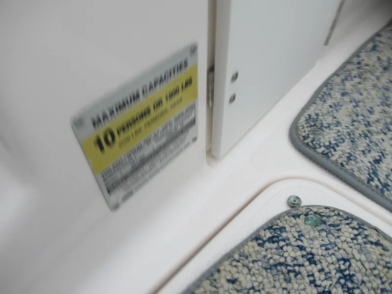 Slide: The Image of 2004 Yamaha Boats SX230 maximum capacity label and interior flooring. - 12