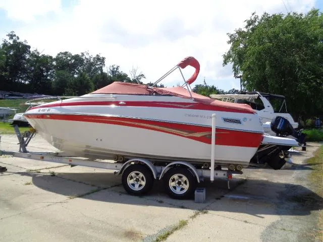 Slide: The Image of 2006 Crownline 220 CCR boat on trailer, red and white design, parked outdoors. - 2