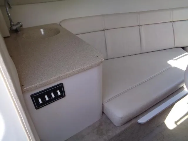 Slide: The Image of 2006 Crownline 220 CCR cabin interior with beige seating and compact sink area. - 23