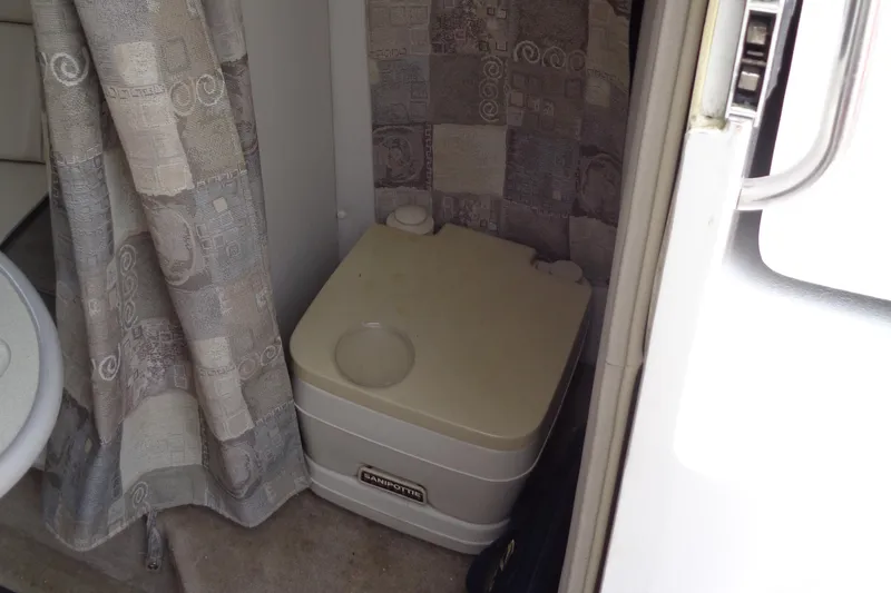Slide: The Image of Portable toilet inside 2006 Crownline 220 CCR boat cabin with patterned curtain. - 24