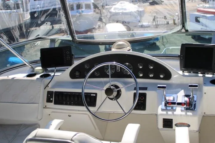Slide: The Image of 1997 Bayliner 4087 Aft Cabin Motoryacht helm with steering wheel and navigation equipment. - 13