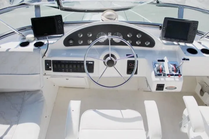 Slide: The Image of 1997 Bayliner 4087 Aft Cabin Motoryacht helm with dual controls and navigation screens. - 15