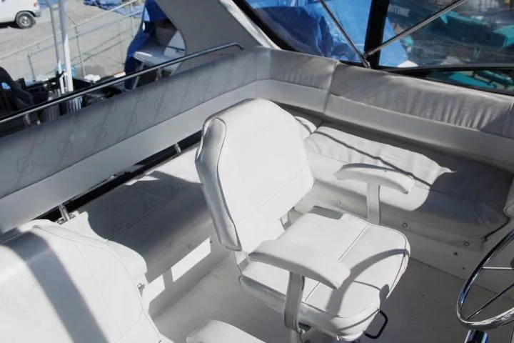Slide: The Image of 1997 Bayliner 4087 Aft Cabin Motoryacht interior with white seating and helm area. - 16