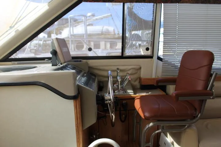 Slide: The Image of 1997 Bayliner 4087 Aft Cabin Motoryacht helm with leather captain's chair and control panel. - 26