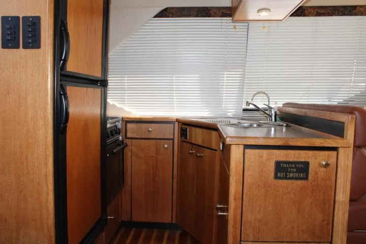 Slide: The Image of 1997 Bayliner 4087 Aft Cabin Motoryacht kitchen with wood cabinetry and compact appliances. - 32