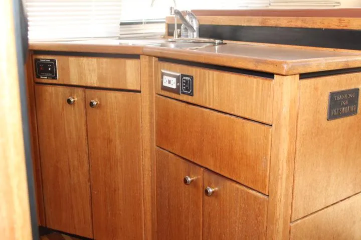 Slide: The Image of 1997 Bayliner 4087 Aft Cabin Motoryacht kitchen with wooden cabinets and sink. - 33