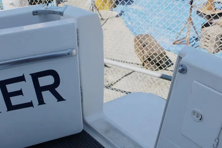 Slide: The Image of 1997 Bayliner 4087 Aft Cabin Motoryacht docked, partial view with chain-link fence background. - 4