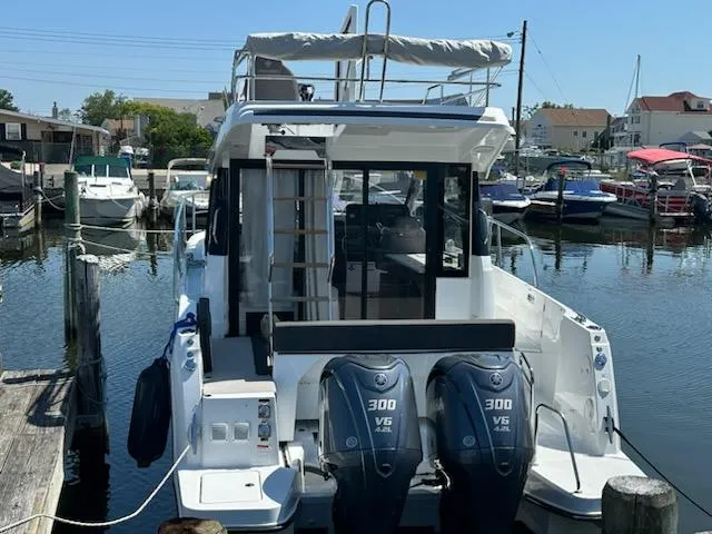 Slide: The Image of 2022 Jeanneau NC 1095 Fly at marina with twin 300 V6 engines. - 2