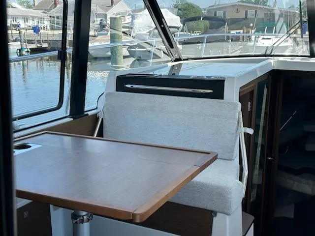 Slide: The Image of Interior of 2022 Jeanneau NC 1095 Fly boat with table and seating by windows. - 3