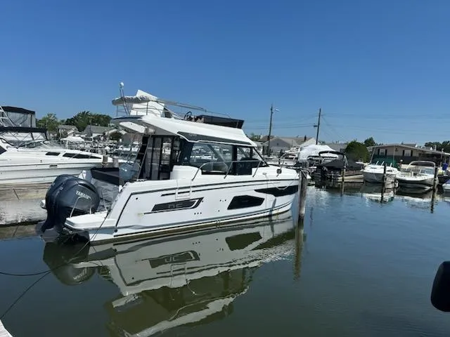 Slide: The Image of 2022 Jeanneau NC 1095 Fly yacht docked in a marina under clear blue skies. - 5