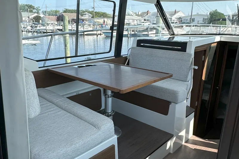 Slide: The Image of Interior of 2022 Jeanneau NC 1095 Fly with dining area and marina view. - 7