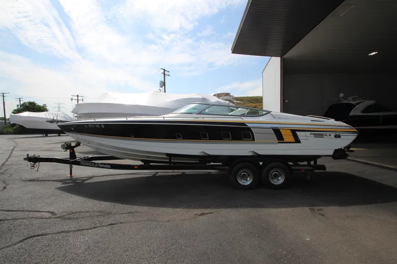 Slide: The Image of 2008 Formula 292 FASTech boat on trailer, parked outdoors under a clear sky. - 0