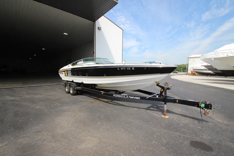 Slide: The Image of 2008 Formula 292 FASTech boat on trailer outside a large garage. - 2
