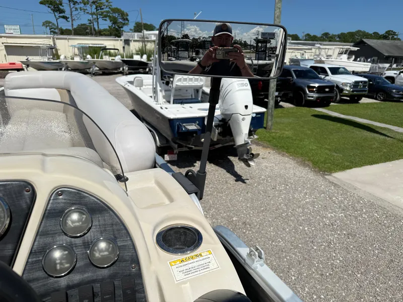 Slide: The Image of 2017 Sweetwater 2286 C boat dashboard with rearview mirror and parked vehicles. - 14