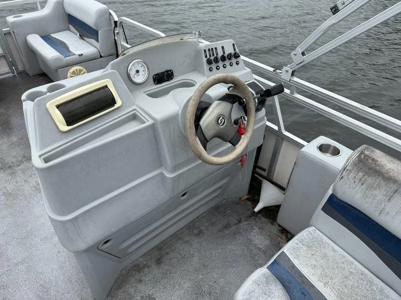 Slide: The Image of 2005 Smoker Craft INFINITY boat interior with steering wheel and seating, on water. - 10