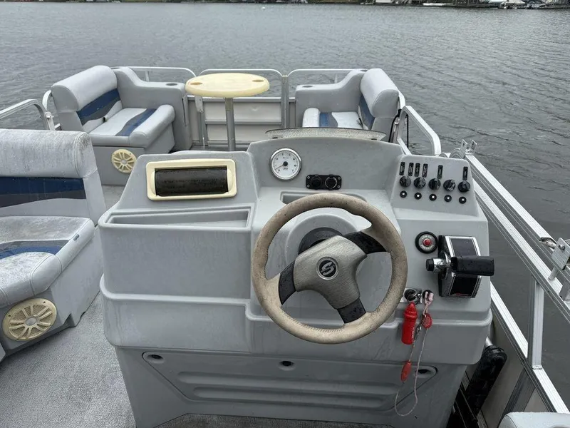 Slide: The Image of 2005 Smoker Craft INFINITY boat interior with steering console and seating, on calm water. - 4