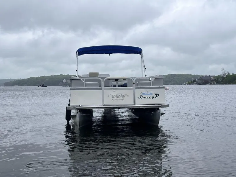 Slide: The Image of 2005 Smoker Craft Infinity pontoon boat on a lake under cloudy skies. - 7