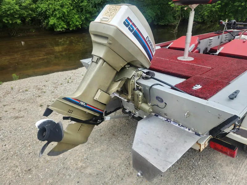 Slide: The Image of 1987 Sea Nymph Traveler boat with Evinrude outboard motor on a riverbank. - 13