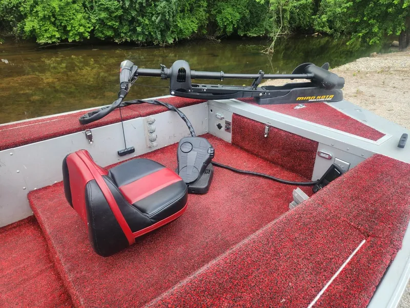 Slide: The Image of 1987 Sea Nymph Traveler boat interior with red carpet and trolling motor by a river. - 5