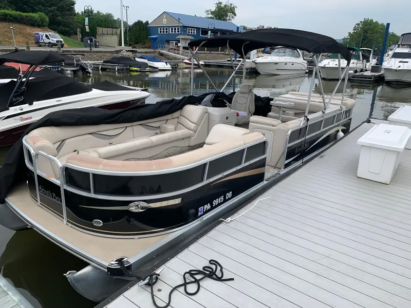 The Image of 2009 South Bay 825 CR pontoon boat docked at marina with covered seating. - 0