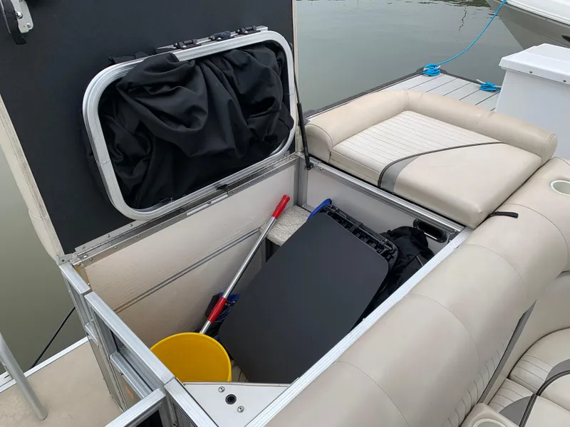 Slide: The Image of Storage compartment on a 2009 South Bay 825 CR boat with cleaning supplies and accessories. - 6