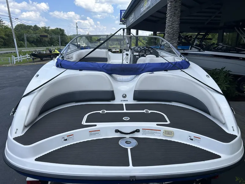 Slide: The Image of 2006 Yamaha Boats SX 210, white and blue, parked outdoors under a cloudy sky. - 2