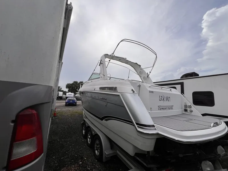 Slide: The Image of 2006 Formula 27 PC boat parked between vehicles in a storage area. - 2