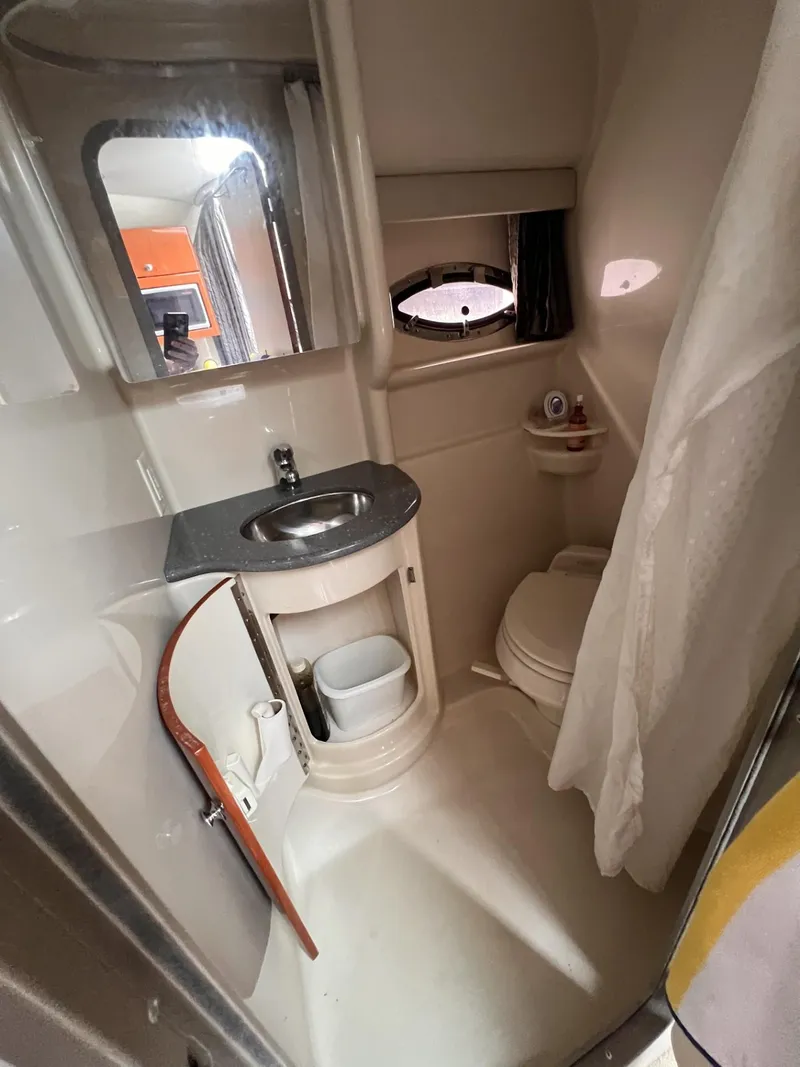 Slide: The Image of Compact bathroom in a 2006 Formula 27 PC boat, featuring sink, toilet, and storage. - 28