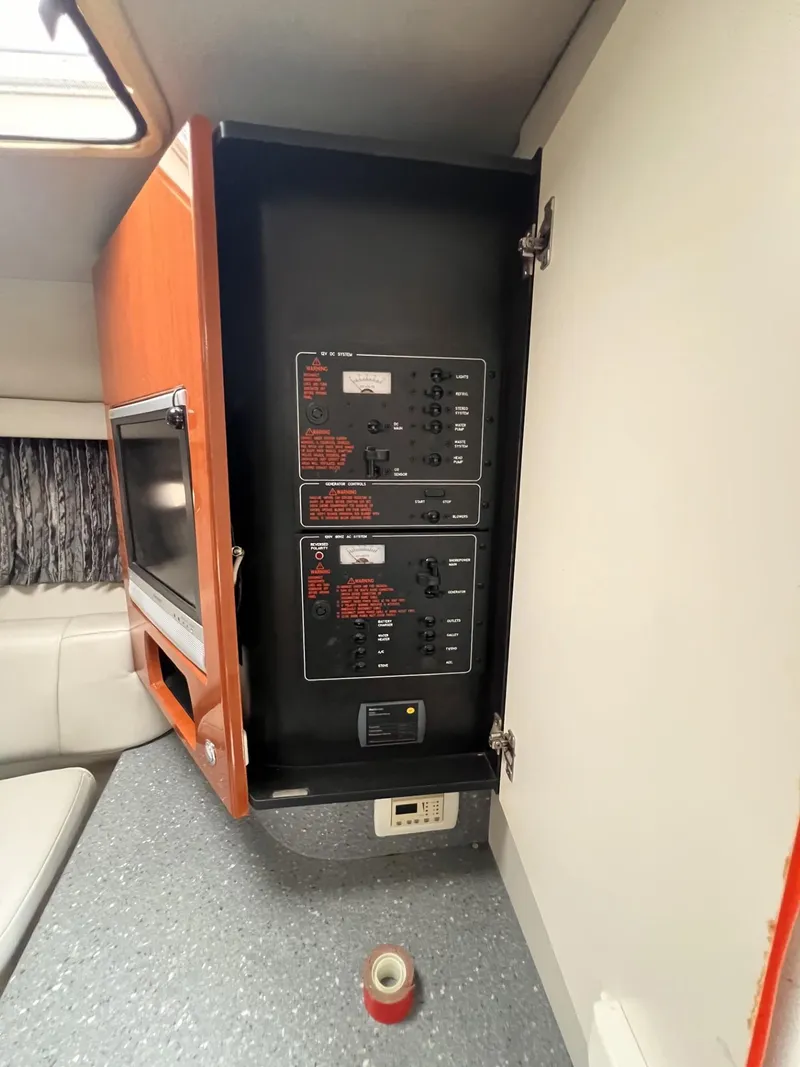 Slide: The Image of Electrical panel inside a 2006 Formula 27 PC boat cabin, featuring control switches and a TV. - 32