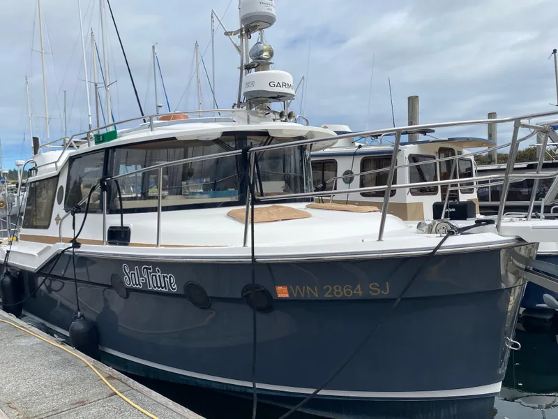 The Image of 2016 Ranger Tugs R-29S boat docked at marina, overcast sky. - 0