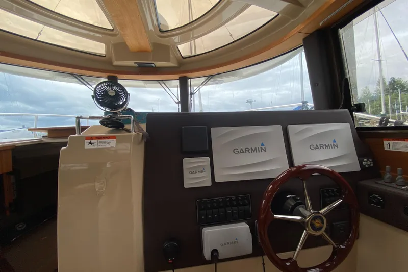 Slide: The Image of 2016 Ranger Tugs R-29S helm with Garmin navigation displays and wooden steering wheel. - 18