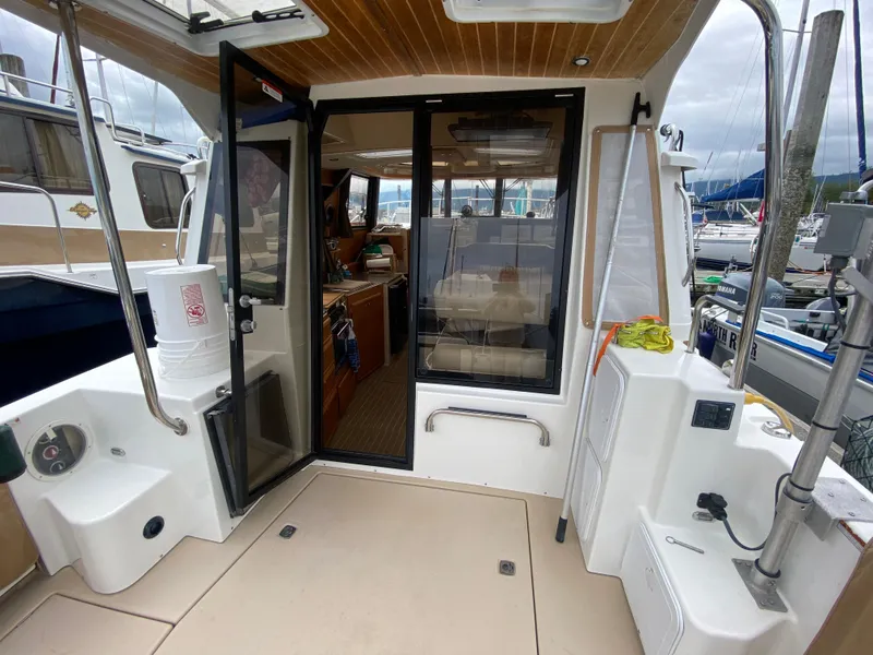 Slide: The Image of 2016 Ranger Tugs R-29S boat interior with open door, docked at marina. - 2