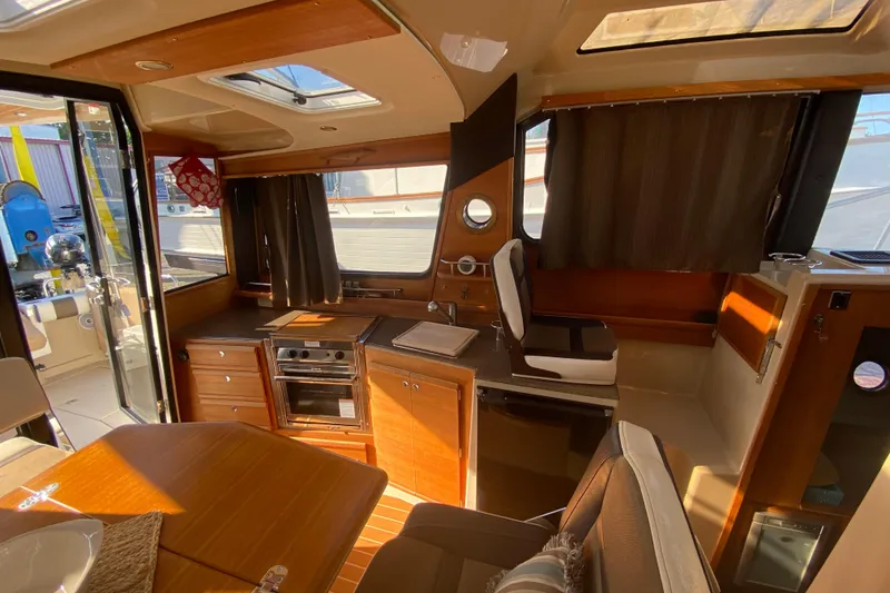 Slide: The Image of Interior of 2016 Ranger Tugs R-29S boat with kitchen and seating area. - 21