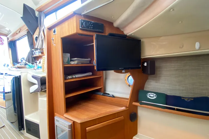 Slide: The Image of Interior of 2016 Ranger Tugs R-29S with TV, shelves, and porthole. - 30