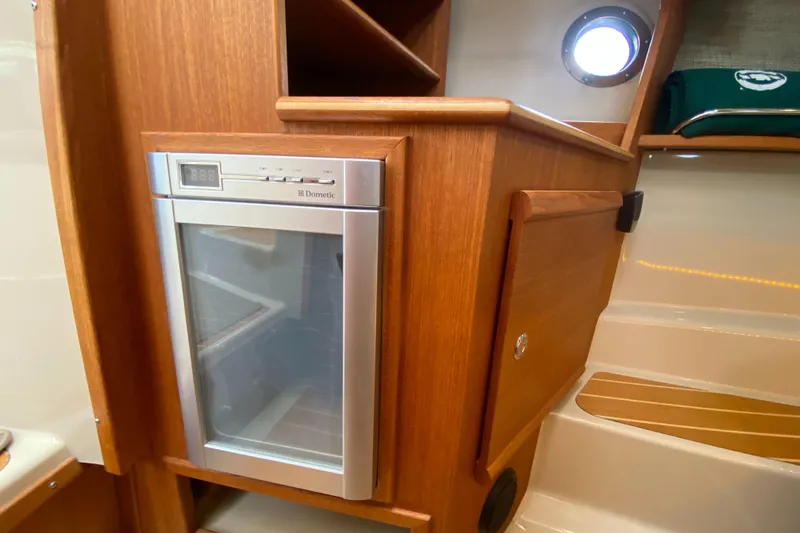 Slide: The Image of 2016 Ranger Tugs R-29S interior with Dometic fridge and wooden cabinetry. - 31