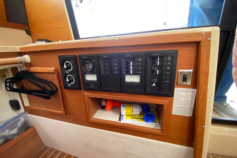 Slide: The Image of 2016 Ranger Tugs R-29S interior control panel with switches and storage compartment. - 35