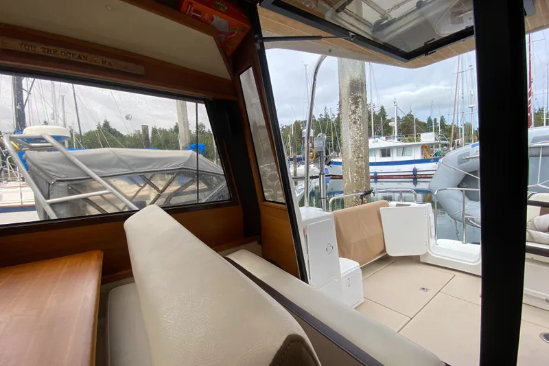 Slide: The Image of Interior view of 2016 Ranger Tugs R-29S, showcasing seating and marina backdrop. - 36