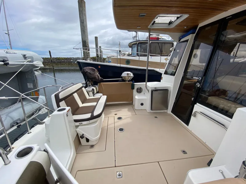 Slide: The Image of 2016 Ranger Tugs R-29S boat deck with seating and marina view. - 4