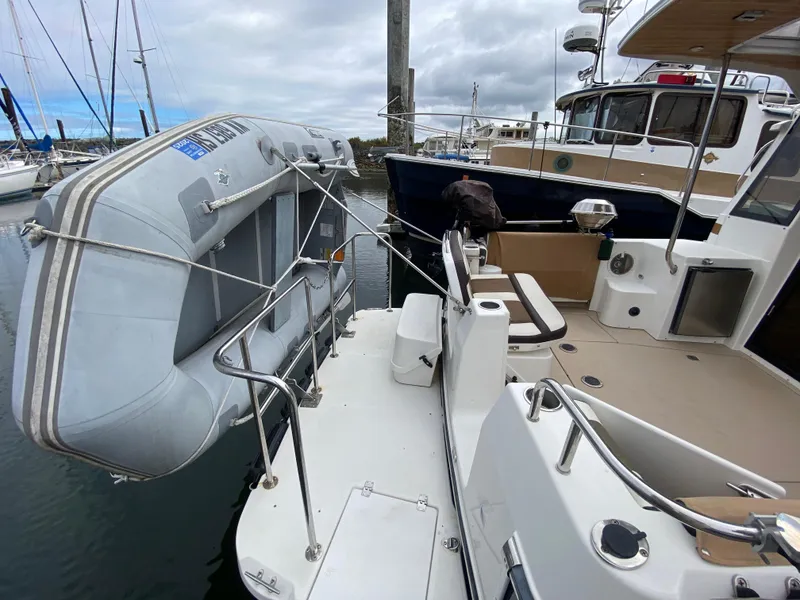 Slide: The Image of 2016 Ranger Tugs R-29S with inflatable dinghy docked at marina. - 6