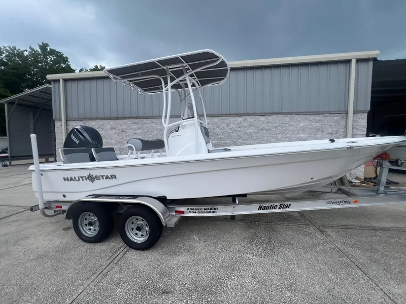 The Image of 2025 NauticStar 214 Shallow Bay boat on trailer, parked outdoors. - 1