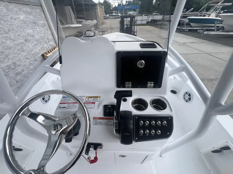 Slide: The Image of 2025 NauticStar 214 Shallow Bay boat console with steering wheel and control panel. - 13