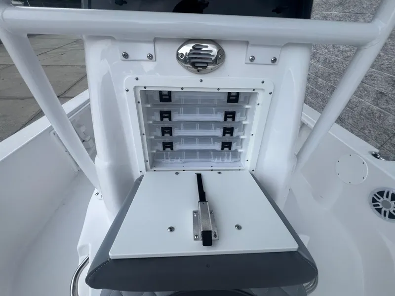 Slide: The Image of 2025 NauticStar 214 Shallow Bay boat storage compartment with organized tackle boxes. - 21
