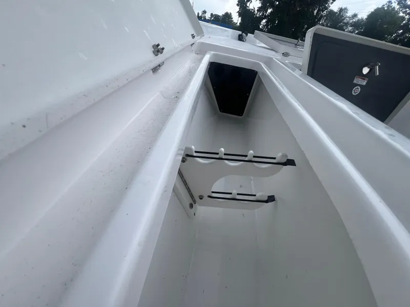Slide: The Image of 2025 NauticStar 214 Shallow Bay boat storage compartment with rod holders. - 26