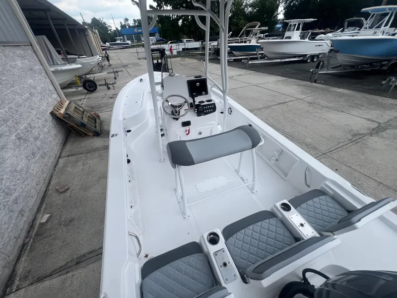 Slide: The Image of 2025 NauticStar 214 Shallow Bay boat interior with seating and steering console. - 5