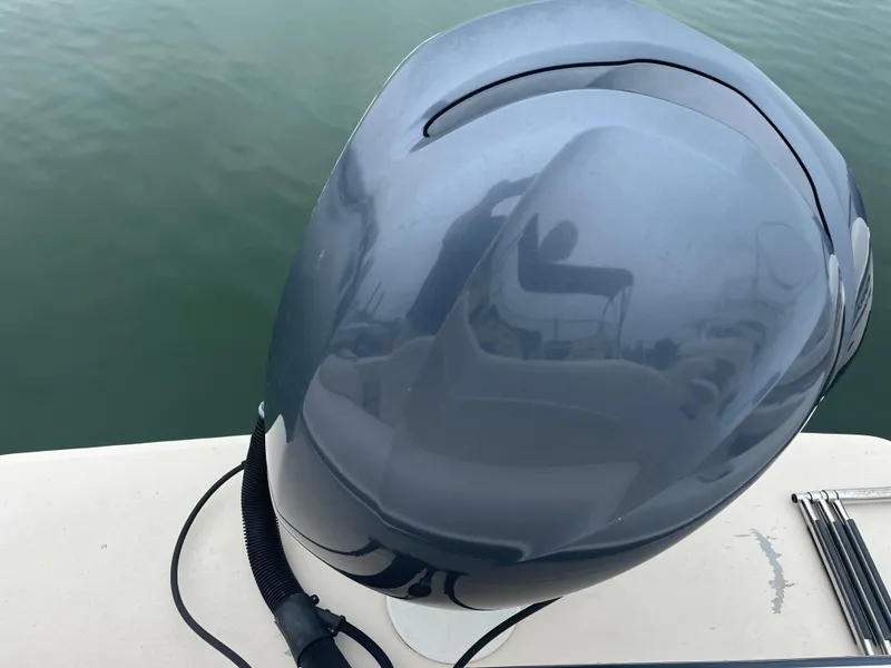 Slide: The Image of Outboard motor on a 2013 Grady-White 22 Seafarer boat, docked on calm water. - 12