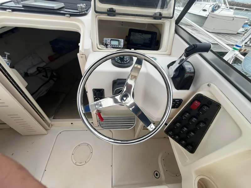 Slide: The Image of 2013 Grady-White 22 Seafarer boat helm with steering wheel and control panel. - 6