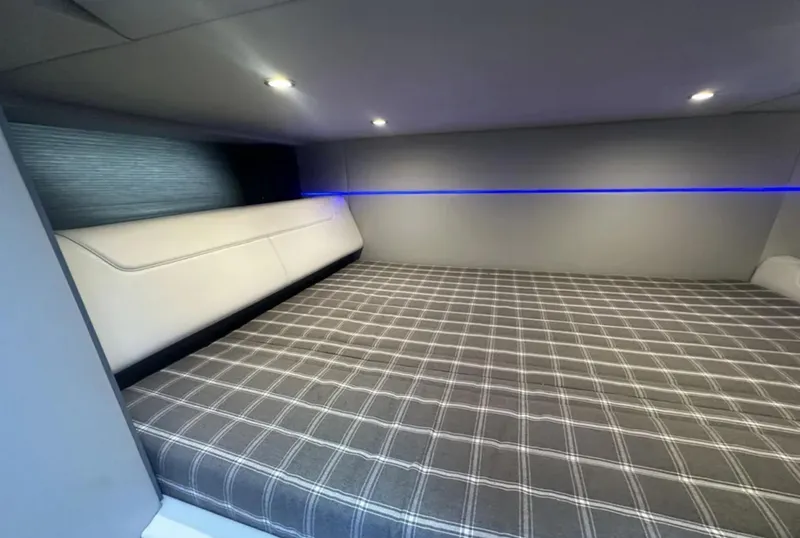 Slide: The Image of 2021 Formula 400 Super Sport Crossover cabin with plaid bedding and modern lighting. - 32