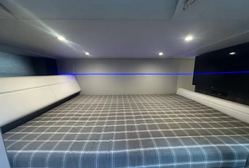 Slide: The Image of 2021 Formula 400 Super Sport Crossover cabin with plaid bedding and ambient lighting. - 33