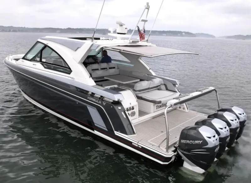 Slide: The Image of 2021 Formula 400 Super Sport Crossover boat with Mercury engines on a calm lake. - 5